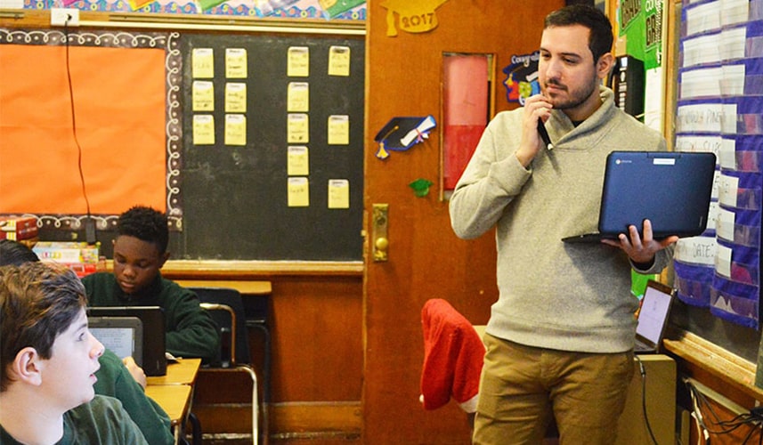 teacher with students and laptop